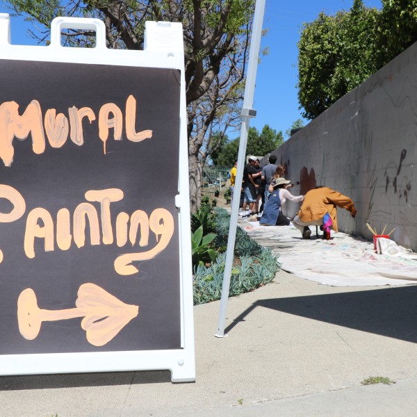 Community members paint a mural