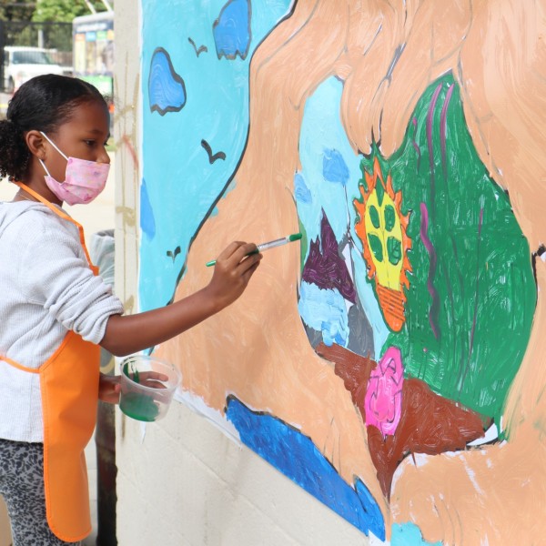 Kids paint a mural at Prende el Sol