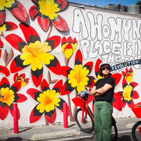 Rider stands in front of mural in Pacoima